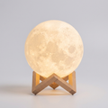 3D moon lamp night light glowing warm on a stand