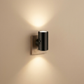 Black plug-in LED night light glowing warm up and down a wall